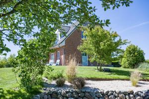 a brick house with a stone wall in front of it at Haushälfte Süderhafen in Nordstrand