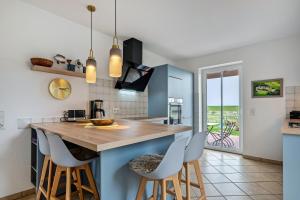 a kitchen with a counter with stools around it at Haushälfte Süderhafen in Nordstrand