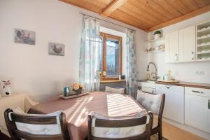a kitchen with a table with chairs and a window at Ferienwohnung Schliersee in Schliersee +17 photos