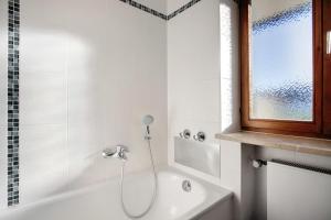 a white bathroom with a shower and a bath tub at Ferienwohnung Schliersee in Schliersee