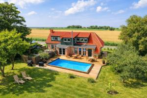 an aerial view of a house with a swimming pool at Ferienhaus 'Huus ant Diek mit Pool' in Norden