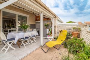 a patio with a table and chairs on it at Maison 38m2 proche de la mer in Gruissan