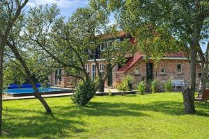 a brick house with a swimming pool in a yard at Ferienhaus 'Huus ant Diek mit Pool' in Norden