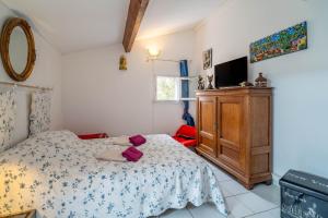 a bedroom with a bed and a tv and a dresser at Maison 38m2 proche de la mer in Gruissan