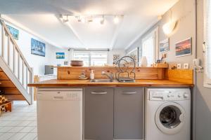 a kitchen with a sink and a washing machine at Maison 38m2 proche de la mer in Gruissan