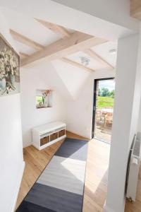a living room with white walls and a large window at Ferienhaus 'Huus ant Diek mit Pool' in Norden +25 photos