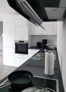 a kitchen with white cabinets and a black skillet on a counter at Rehkitz in Baiersbronn