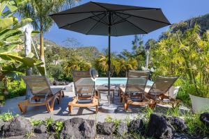 a group of chairs and a table with an umbrella at Finca El Dragonal With Private Pool in Santa Brígida