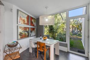 a dining room with a white table and some windows at Finca El Dragonal With Private Pool in Santa Brígida