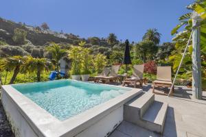 a swimming pool in the middle of a patio with chairs and trees at Finca El Dragonal With Private Pool in Santa Brígida
