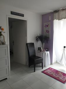 a bedroom with a black chair and a table at Chambre Chanteloup in Mont-Dol +2 photos