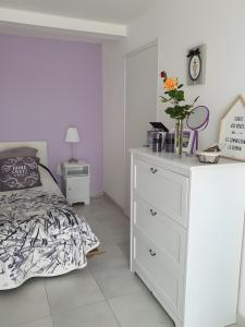 a white bedroom with a bed and a dresser at Chambre Chanteloup in Mont-Dol