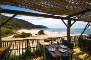 a table on a balcony with a view of the beach at Le Chalet De La Plage in Coti-Chiavari