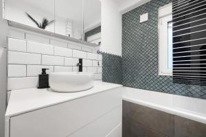 a white bathroom with a sink and a tub at Gemütliche und ruhige Wohnung in Stuttgart +12 photos