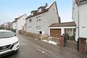 a white car parked in front of a house at Gemütliche und ruhige Wohnung in Stuttgart