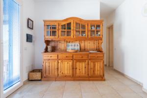 a wooden cabinet in a room with a tile floor at Sottotorre 1 in Calasetta