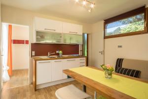 a kitchen with white cabinets and a table at Ferienhaus Falkenhalde in Deggenhausertal