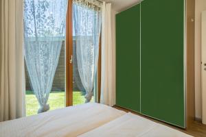 a bedroom with a bed and a large window at Ferienhaus Falkenhalde in Deggenhausertal