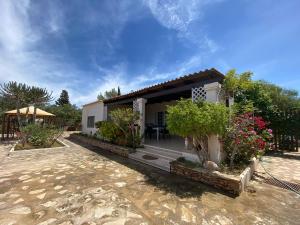 a small white house with some plants and flowers at Casa Can Mussenya in Illes Balears