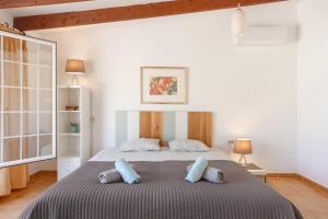 a bedroom with a large bed with blue pillows at Casa Can Mussenya in Illes Balears +24 photos