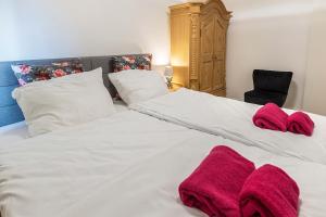 a bedroom with two white beds with red towels on them at Traumwohnung Radolfzell am Bodensee in Radolfzell am Bodensee