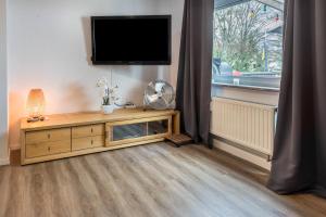 a living room with a television and a wooden cabinet at Traumwohnung Radolfzell am Bodensee in Radolfzell am Bodensee