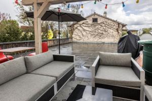 a patio with two couches and an umbrella at Traumwohnung Radolfzell am Bodensee in Radolfzell am Bodensee