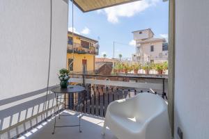 a balcony with a chair and a table on a balcony at Bellini House in Viagrande
