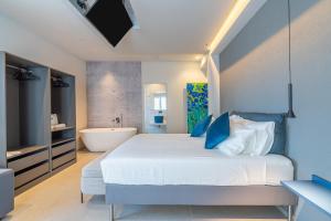 a bedroom with a white bed and a bath tub at Bellini House in Viagrande