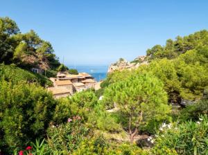 a view of the ocean from a hill with trees at Sa Cala in Deia