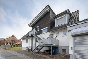 ein weißes Haus mit einer Metalltreppe darauf in der Unterkunft Rosensteinferien in Heubach