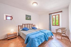 ein Schlafzimmer mit einem Bett, einem Stuhl und einem Fenster in der Unterkunft Son Maimo in Petra + 19 Fotos