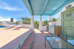 an outdoor patio with a glass table and chairs at Casa Penthouse in Porto Rotondo