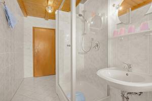 a white bathroom with a shower and a sink at Ferienwohnung König im Obergeschoss in Berchtesgaden +9 photos