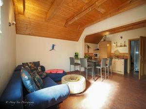 a living room with a blue couch and a table at Birkenhof Pließkowitz in Malschwitz +5 photos