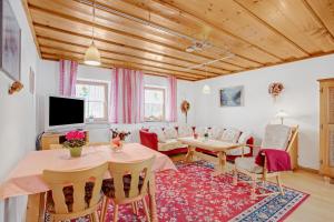 a living room with a table and a tv at Ferienwohnung König im Obergeschoss in Berchtesgaden