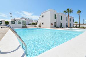a swimming pool in front of a villa at Mimosa B1 in Puerto del Carmen