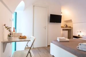 a bedroom with a desk and a bed and a table at Suite Le Cementine in Mottola