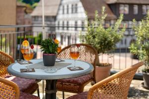 a table with two glasses of wine on a balcony at Urlaub Im Kulturdenkmal in Alpirsbach