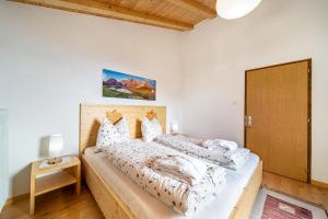 a bedroom with two beds and a wooden door at Eggerhof Familienparadies in Verano