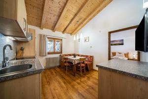 a kitchen with a table and a dining room at Eggerhof Familienparadies in Verano