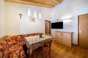 a dining room with a table and a cross on the wall at Eggerhof Familienparadies in Verano