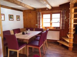 a dining room with a wooden table and purple chairs at Biobetrieb Lippenhof in Breitnau