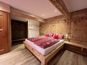 a bedroom with a bed in a room with wooden walls at Biobetrieb Lippenhof in Breitnau