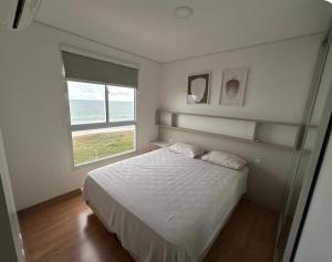 a bedroom with a bed and a large window at Resort com vista mar! in Barra Velha +45 photos