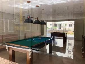 a billiard room with a pool table and a piano at Resort com vista mar! in Barra Velha
