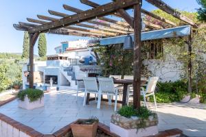 a patio with a table and chairs under a wooden pergola at Habitacion Doble Jardin in Camarles