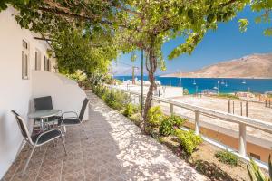 a patio with a table and chairs and a view of the water at Panorama Tilos Apt B in Tílos