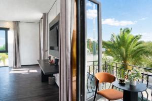 a room with a balcony with a view of a palm tree at H- Dragon Hotel in Ðố Sơn