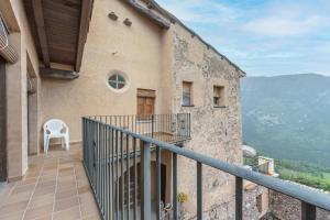 a balcony of a building with a chair on the side at Casa Vilanova in Peramea